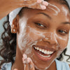 young woman smiling while washing face with Pore Perfecting Cleanser hover