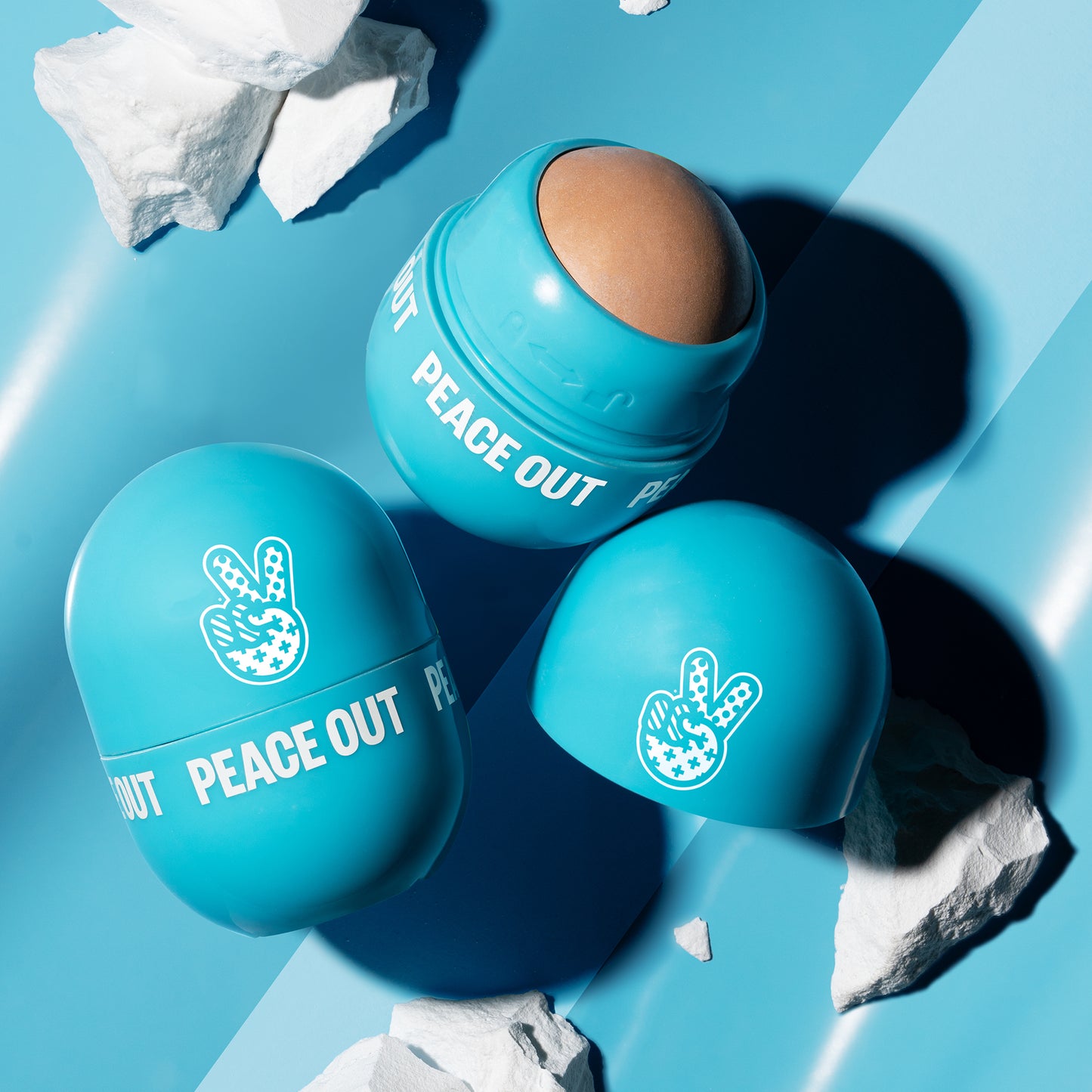 Three Peace Out Oil Control Rollers in bright turquoise blue, with one open capsule showing the Halloysite clay inside. 
