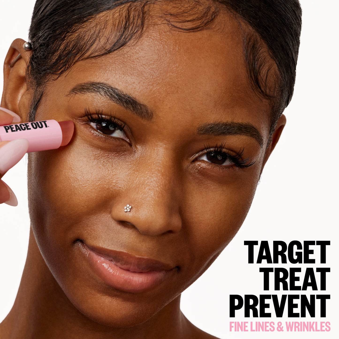 A woman applies Peace Out Retinol Eye Jelly Stick under her eye next to the caption 'Target, Treat, Prevent Fine Lines & Wrinkles'