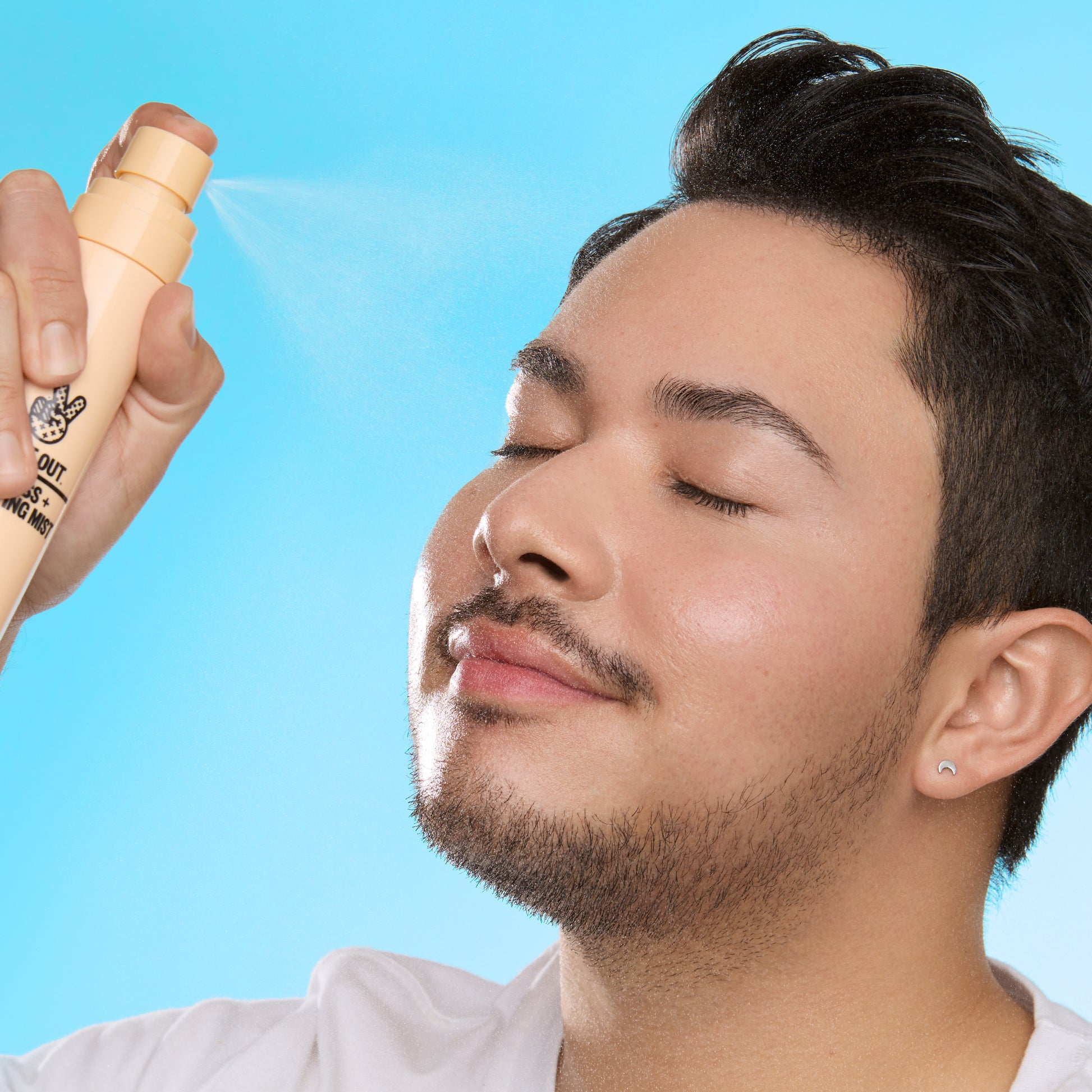 Young man sprays face with Redness Clarifying Mist - hover